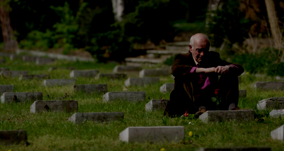 Sohn eines der in Treuenbrietzen von der Wehrmacht ermordeten Italienischen Kriegsinternierten sitzt auf dem Friedhof vor dem Grab seines Vaters