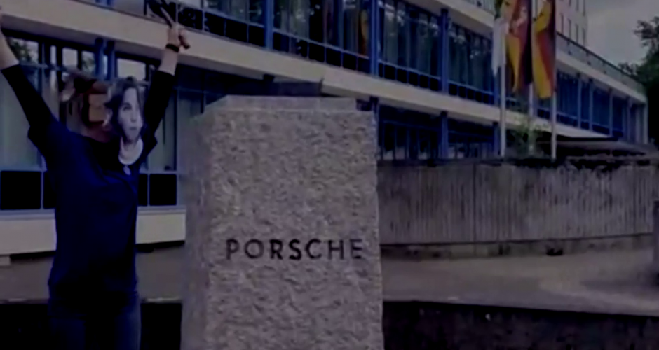 Sockel ohne Büste mit Aufschrift Porsche daneben Frau mit Hammer in Siegespose