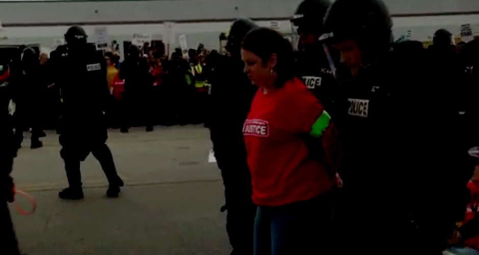 Streikende Walmart Arbeiterin wird von der Polizei abgeführt