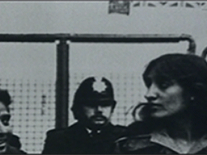 Zwei Grunwick Arbeiterinnen beim Streikposten stehen, im Hintergrund ein Polizist