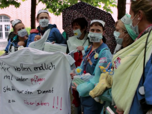 Krankenpflegerinnen mit Transparent: Wir wollen endlich mal wieder pflegen statt nur den Dienst zu überleben!!!