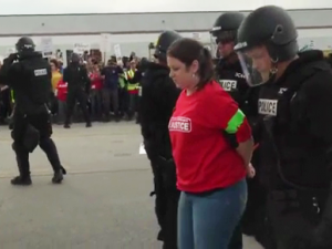 Streikende Walmart Arbeiterin wird von der Polizei abgeführt